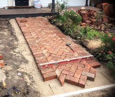 a brick walkway being built in front of a house