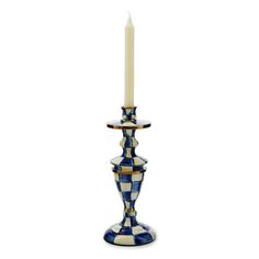 a blue and white checkered candle holder with a lit candle in the middle on a white background