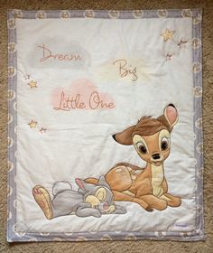 a baby blanket with an image of a deer and a mouse on it, that says dream big by little one