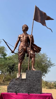 a statue of a man with a bow and arrow in front of a red table cloth