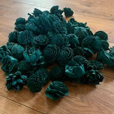 a pile of green flowers sitting on top of a wooden floor