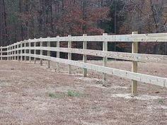 a wooden fence in the middle of a field