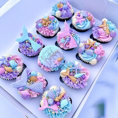 cupcakes decorated in pastel blue and purple icing with mermaid themed decorations