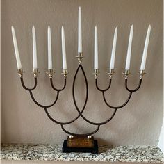 a menorah with seven candles in it sitting on a countertop next to a wall