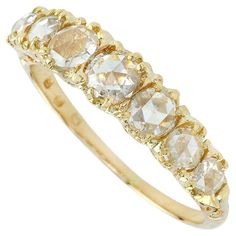 a yellow gold ring with five stones on it's sides and three rows of diamonds in the middle