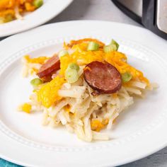 two white plates topped with pasta and sausages next to an instant pot pressure cooker