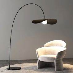 the floor lamp is next to a white chair with a black light on it,