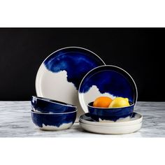 blue and white dinnerware set with oranges in the center, on a marble table