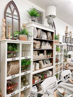 a room filled with lots of white furniture and plants on top of shelves next to each other