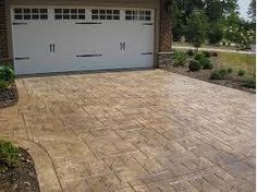 a driveway with a brick paver and two garage doors on the side of it