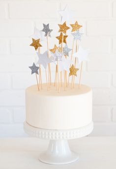 a white cake with gold and silver stars on top