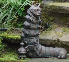 an animal statue sitting on top of some moss