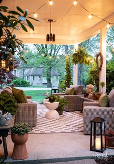 a covered patio with wicker furniture and potted plants