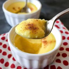 two small bowls filled with pudding on top of a red and white table cloth