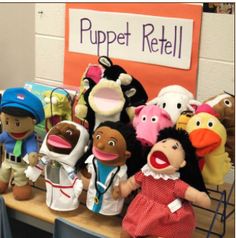 several stuffed animals sitting on top of a wooden table next to a sign that says puppet retail