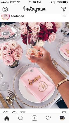 the table is set with pink flowers and silverware for an elegant wedding reception or special occasion