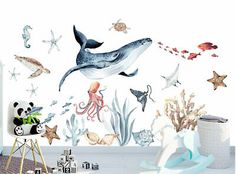 an ocean themed nursery room with sea animals and marine life on the wall, along with toys