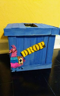 a blue box with a sign that says drop on it and a bird holding a skateboard