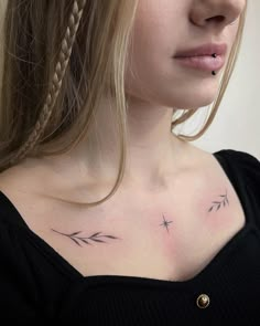 a woman with a cross tattoo on her chest and behind her ear is a braid