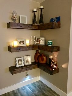 some shelves with pictures and candles on them in a corner by the wall or floor