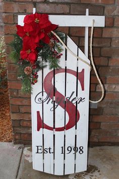 a sign that is on the side of a building with christmas decorations hanging from it