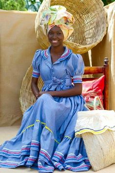 a woman sitting on top of a wooden chair in front of a wicker basket