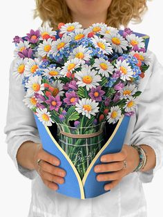 a woman holding a bouquet of daisies in her hands and wearing a white lab coat