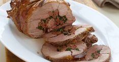 sliced meat sitting on top of a white plate