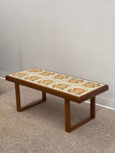 a coffee table sitting on top of a carpeted floor next to a white wall