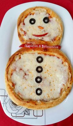 two pizzas with faces on them sitting on a plate