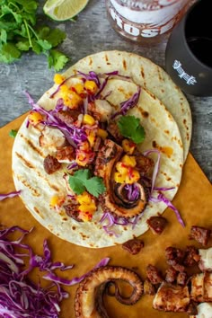 two tacos with meat and vegetables on a cutting board