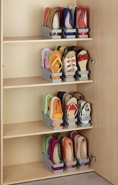 several pairs of shoes are on shelves in a closet