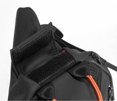 an orange cord is attached to the back of a black duffel bag on a white background