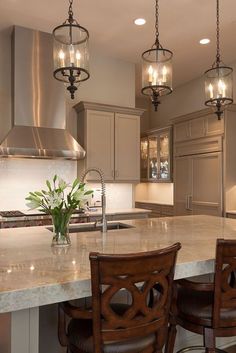 a large kitchen with an island and bar stools next to the stove top oven