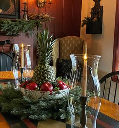 a pineapple centerpiece on a dining room table with candles and other holiday decorations