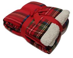 two blankets folded up with a red bow on top and plaid blanketing around the edges