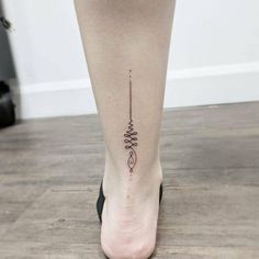 a woman's foot with a small tattoo on the side of her leg and an arrow