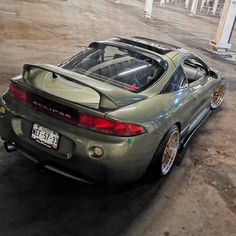 the rear end of a sports car parked in a parking lot