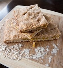 some food that is on top of a wooden cutting board and ready to be eaten