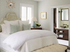 a white bed sitting in a bedroom next to a dresser with drawers and lamps on top of it