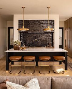 a kitchen island with four stools in front of it