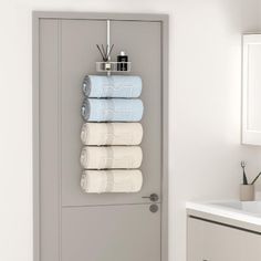 a towel rack with five towels hanging on it's side next to a bathroom sink