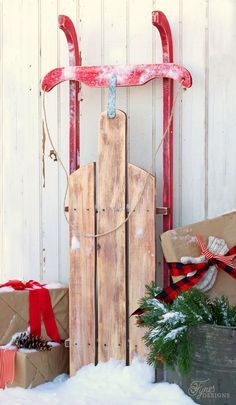 an old sled with christmas presents in front of it and snow on the ground