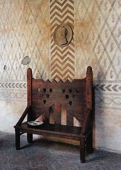 a wooden bench sitting in front of a wall with hearts on it's back