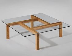 a glass table with wooden legs on a grey background, it appears to be made from wood