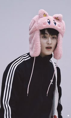 a young man wearing a pink hat with ears on top of his head and an animal ear flap