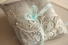 a decorative pillow with beading and ribbon on the back is sitting on a couch