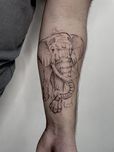 an elephant tattoo on the left arm