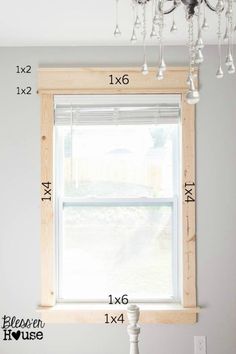 a window with measurements for the height of it in front of a chandelier