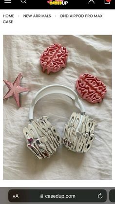 two pink and white headphones sitting on top of a bed next to each other